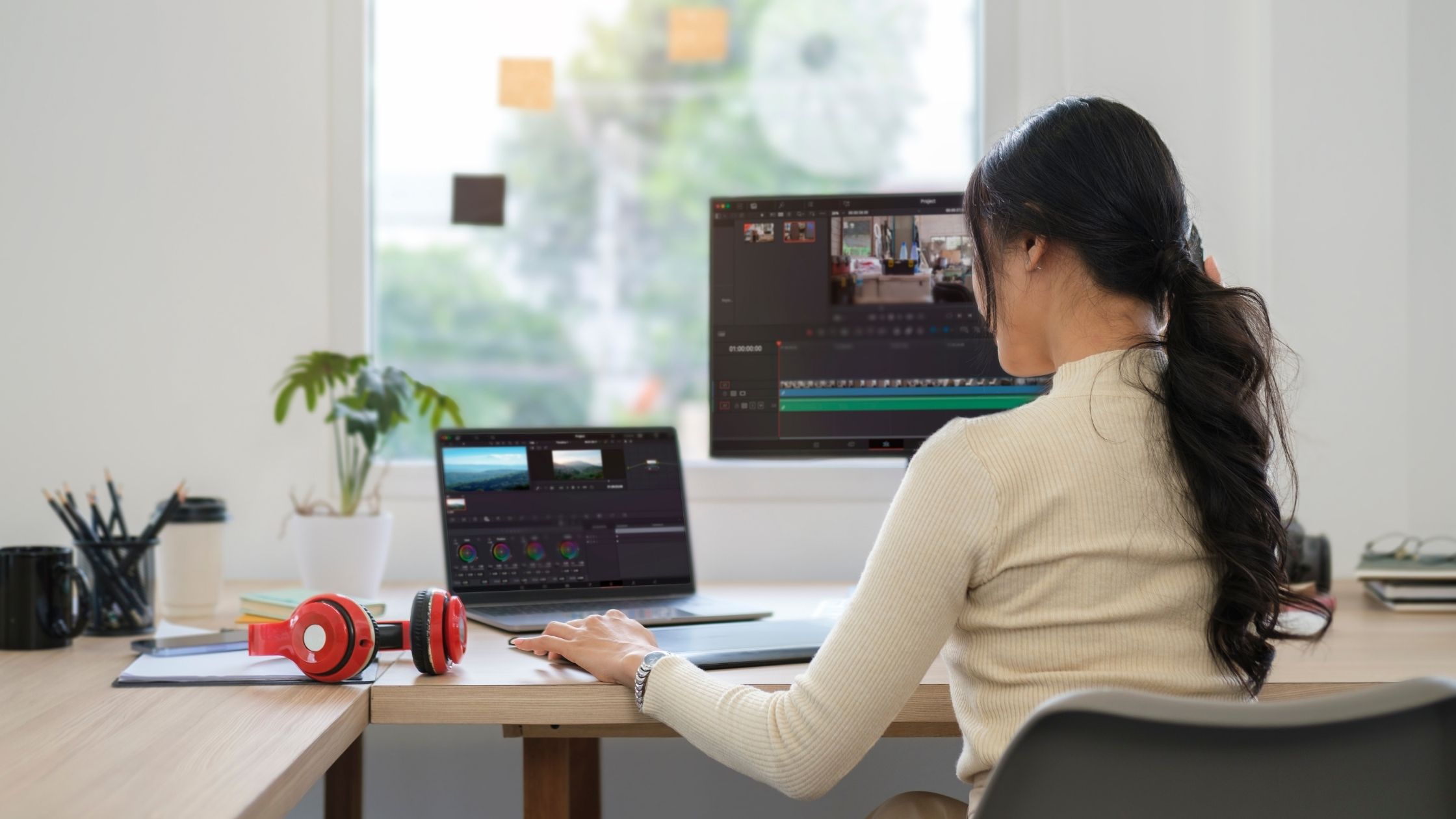 Person sat at a desk editing a video on a laptop