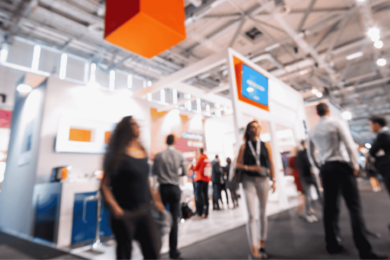 multiple people walking around at a trade show with exhibition stands