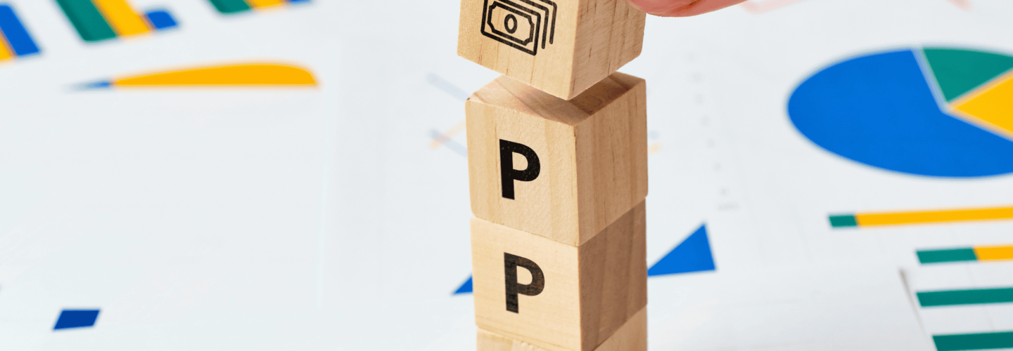 wooden blocks with PPC written on them with graphs in the background